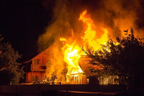 A home burning amidst trees