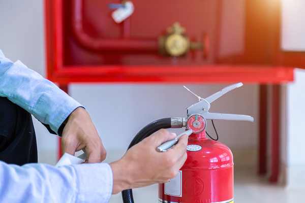 A technician checking a fire extinguisher