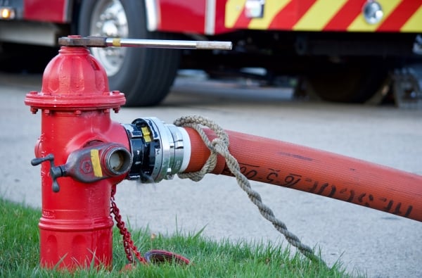 A fire hydrant with a hose attached