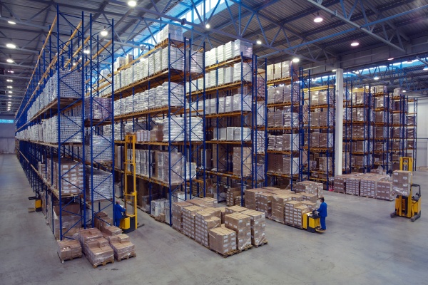 The interior of a large goods warehouse with shelves of pallet rack system storage.
