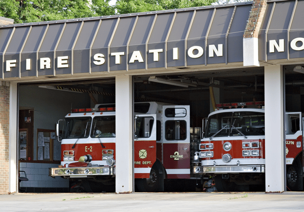 A fire station with multiple trucks inside its garage