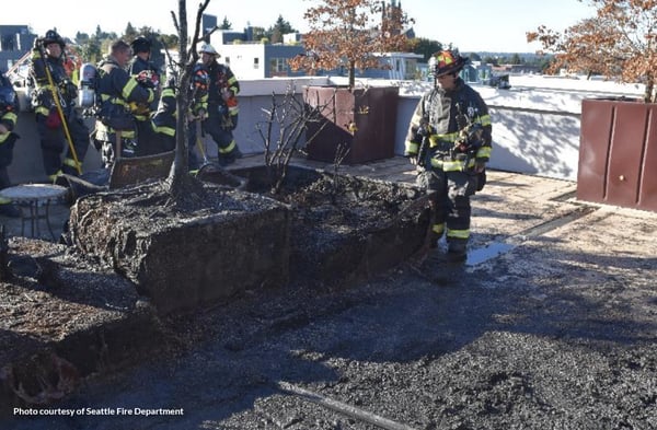 A Seattle firefighter examines the remains of a rooftop deck fire