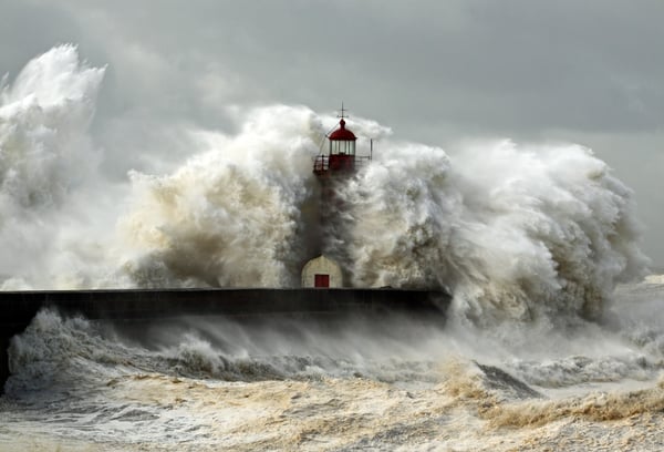 A tsunami (tidal wave) hits a lighthouse