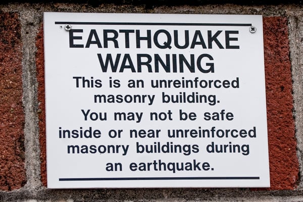 Earthquake warning sign outside of an unreinforced masonry building