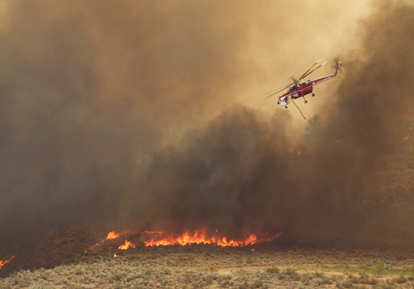 Helicopter attempts to control a wildfire burning in Washington state